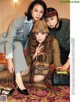 A couple of women sitting next to each other on a rug.