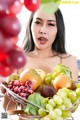 A woman holding a basket of fruit in her hands.