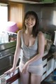 A woman standing in a kitchen next to a sink.